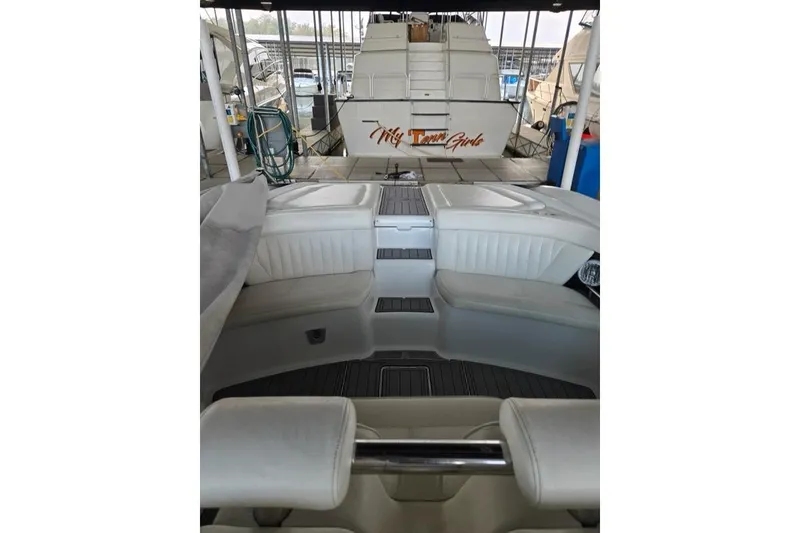 Slide: The Image of 2007 Cobalt 343 boat interior with white seating and docked yacht in background. - 43