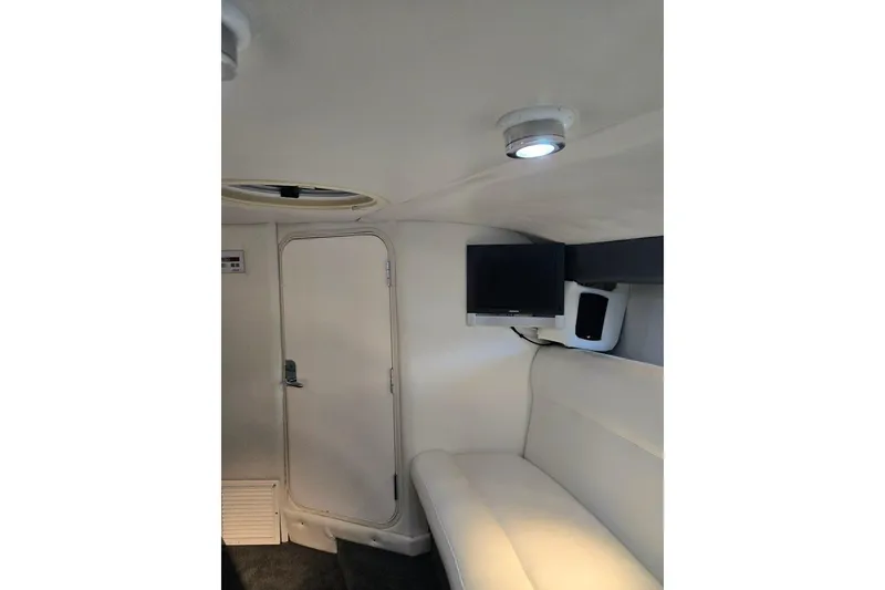 Slide: The Image of Interior of a 2007 Cobalt 343 boat with white seating and a mounted TV. - 51