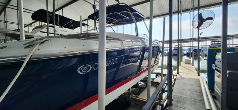 Slide: The Image of 2007 Cobalt 343 boat docked in a marina under a covered structure. - 7