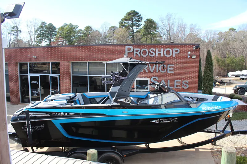 Slide: The Image of 2023 Tigé 23ZX boat in front of a pro shop, showcasing sleek design and vibrant colors. - 4