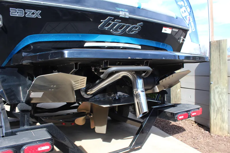 Slide: The Image of 2023 Tigé 23ZX boat rear view, showcasing propeller and exhaust system. - 5