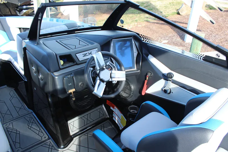 Slide: The Image of 2023 Tigé 23ZX boat cockpit with modern steering wheel and touchscreen display. - 9