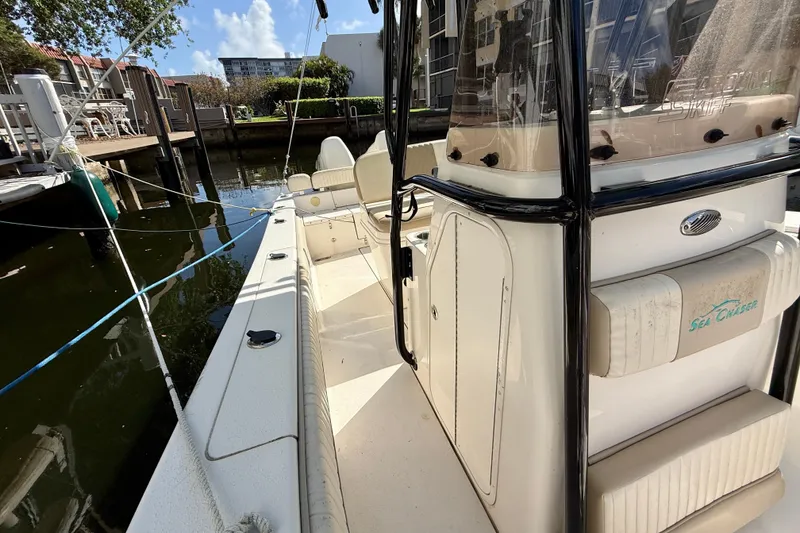 Slide: The Image of 2018 Sea Chaser 24 HFC boat docked, showcasing interior seating and console. - 11