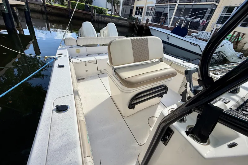 Slide: The Image of 2018 Sea Chaser 24 HFC boat interior with seating and console, docked by the water. - 13