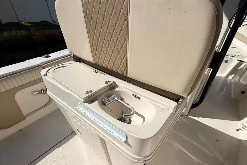 Slide: The Image of 2018 Sea Chaser 24 HFC boat interior with beige seating and storage compartment. - 23