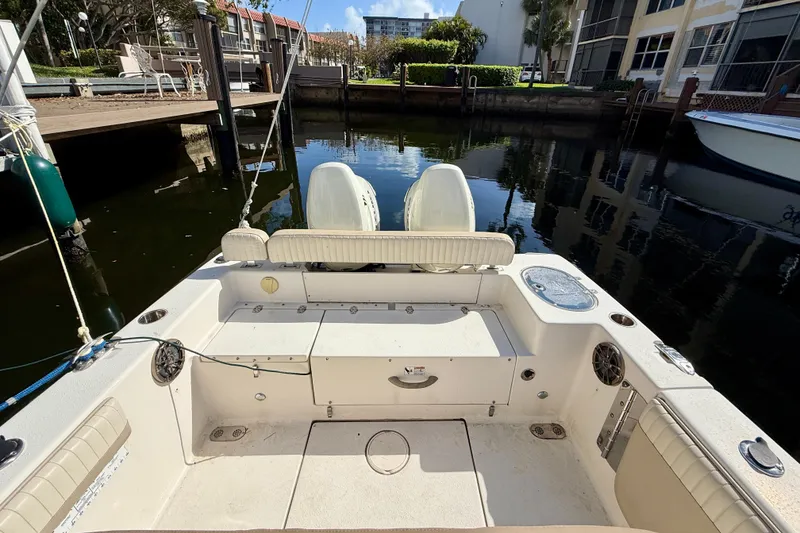 Slide: The Image of 2018 Sea Chaser 24 HFC boat interior at a dock, featuring seating and storage. - 24