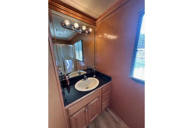 Slide: The Image of Luxurious bathroom in 2004 Sumerset 16x82 houseboat with wood cabinetry and modern fixtures. - 14