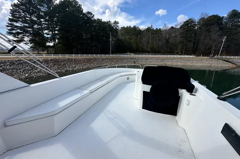 Slide: The Image of 2004 Sumerset 16x82 houseboat deck with seating, surrounded by trees and water. - 19