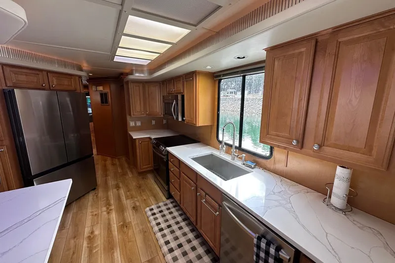 Slide: The Image of Luxurious kitchen interior of 2004 Sumerset 16x82 houseboat with modern appliances and wood cabinetry. - 4