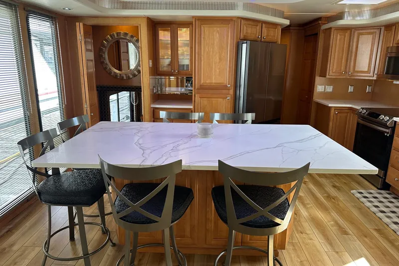 Slide: The Image of Luxurious kitchen interior of 2004 Sumerset 16x82 houseboat with marble island and wooden cabinetry. - 5