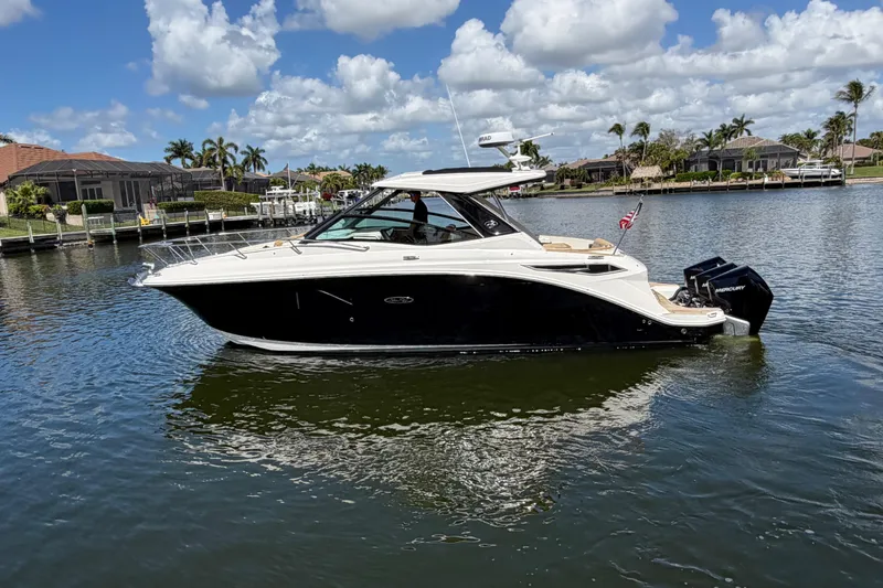 The Image of 2020 Sea Ray Sundancer 320 Outboard cruising on a sunny day in a scenic waterway. - 0