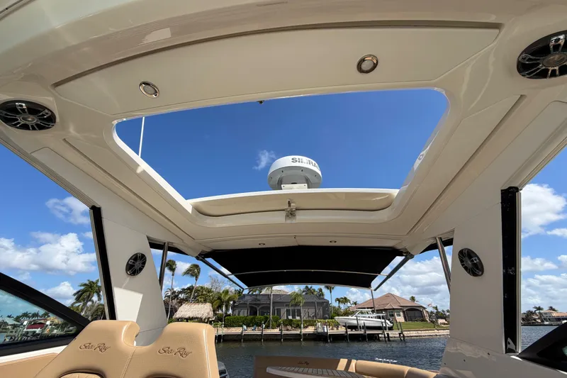 Slide: The Image of 2020 Sea Ray Sundancer 320 Outboard interior with open sunroof, showcasing waterfront view. - 17