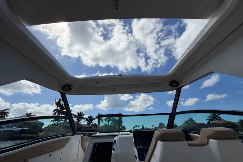 Slide: The Image of Interior view of 2020 Sea Ray Sundancer 320 Outboard with open sky and palm trees. - 18