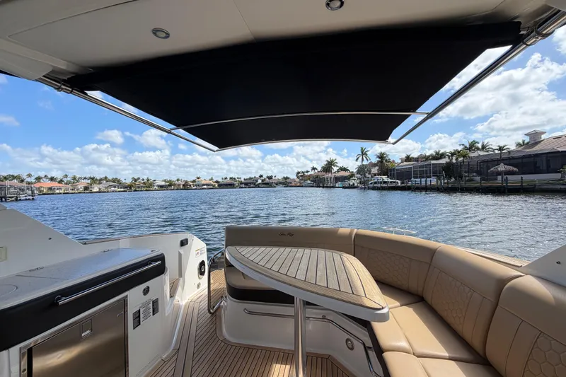 Slide: The Image of 2020 Sea Ray Sundancer 320 Outboard interior with waterfront view, featuring seating and table. - 19