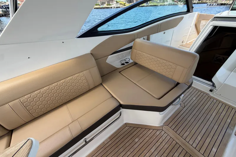 Slide: The Image of 2020 Sea Ray Sundancer 320 Outboard interior with tan seating and wood flooring. - 20