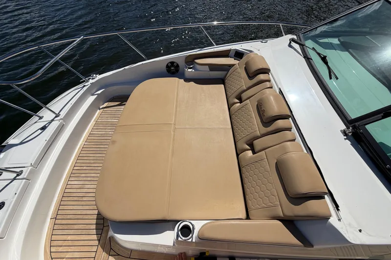 Slide: The Image of 2020 Sea Ray Sundancer 320 Outboard with tan seating on deck, near water. - 25
