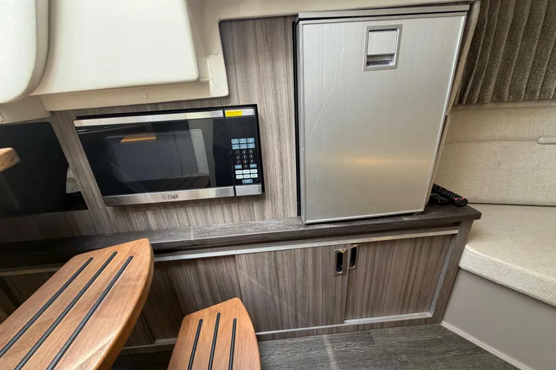Slide: The Image of 2020 Sea Ray Sundancer 320 Outboard interior with microwave and compact fridge. - 29