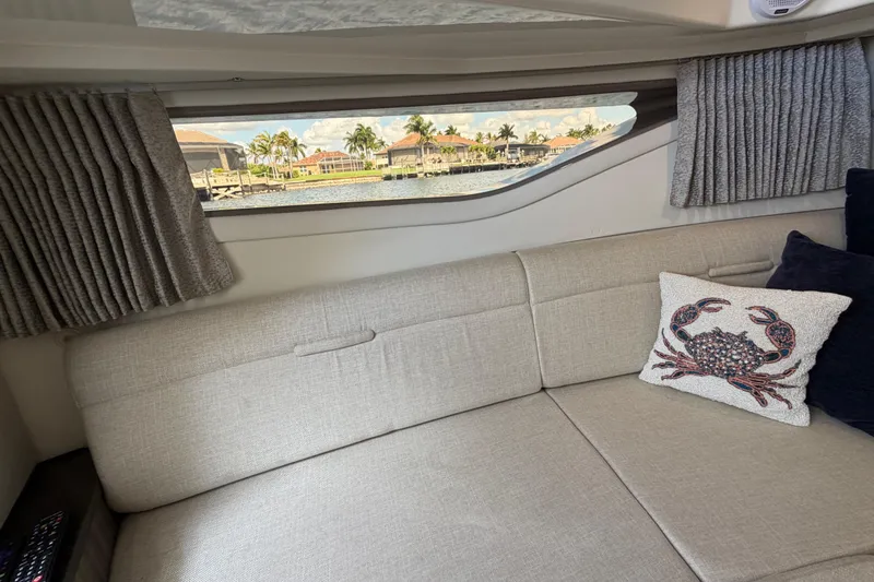 Slide: The Image of Interior of 2020 Sea Ray Sundancer 320 Outboard with scenic window view and crab-themed pillow. - 31