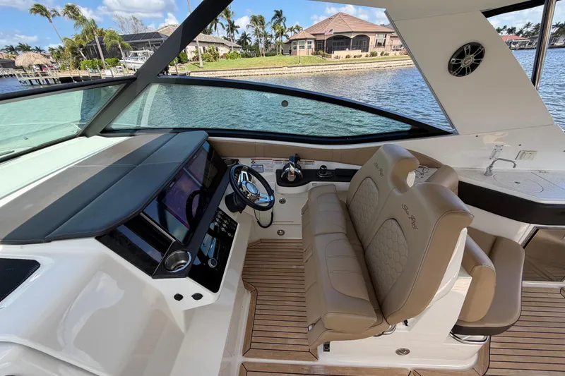 Slide: The Image of 2020 Sea Ray Sundancer 320 Outboard helm with luxurious seating and modern controls. - 9