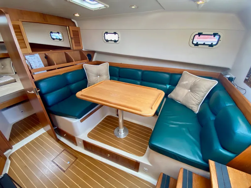 Slide: The Image of Interior of a 2000 Mainship Pilot 34 yacht with wood flooring and green upholstery. - 18
