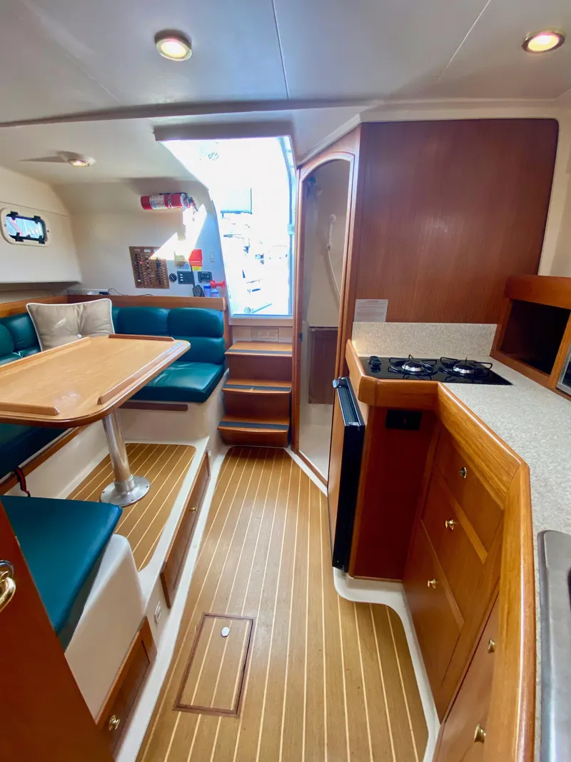 Slide: The Image of Interior of a 2000 Mainship Pilot 34 yacht with wood flooring and seating area. - 20