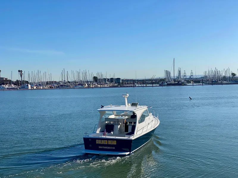 Slide: The Image of 2000 Mainship Pilot 34 cruising on calm waters near marina. - 6