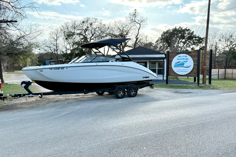The Image of 2025 Yamaha Boats 252SE on trailer outside Elite Marine dealership. - 1