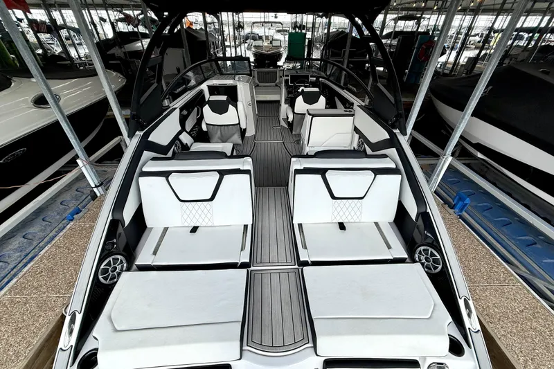 Slide: The Image of 2025 Yamaha Boats 252SE interior with sleek seating and modern design in a marina setting. - 17