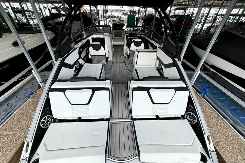 Slide: The Image of 2025 Yamaha Boats 252SE interior with sleek seating and modern design in a marina setting. - 18