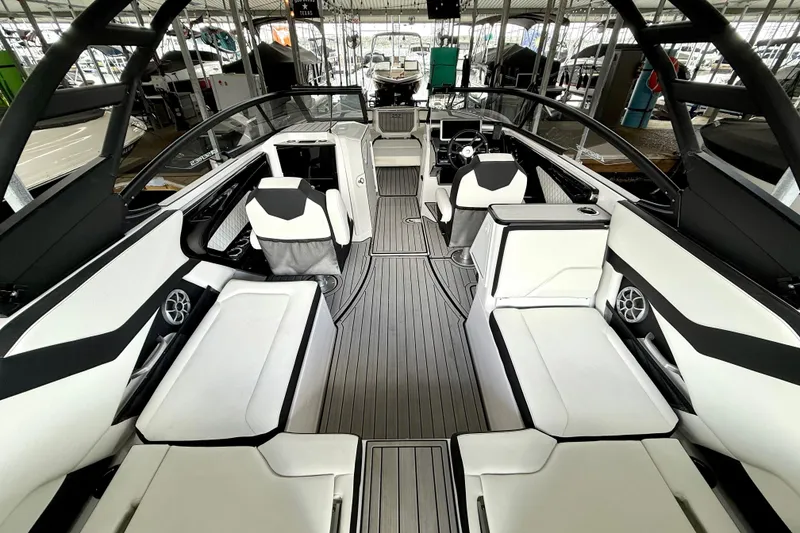 Slide: The Image of 2025 Yamaha Boats 252SE interior with sleek seating and modern design in a marina setting. - 19