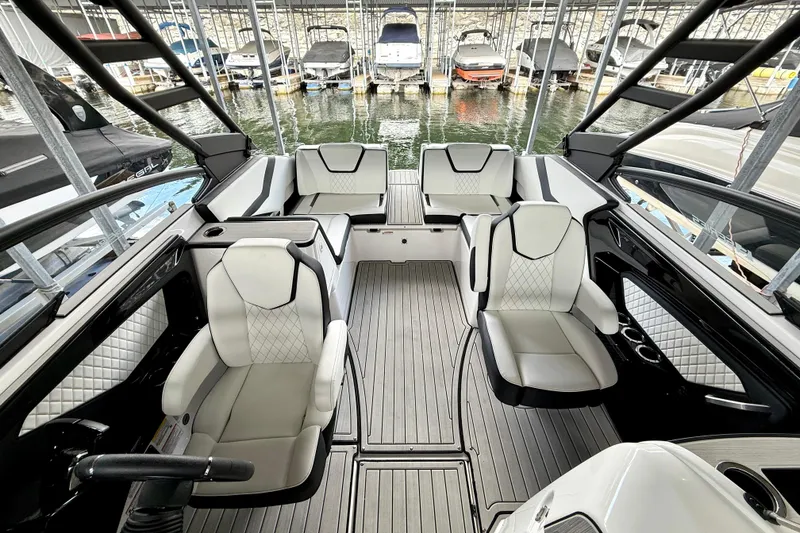 Slide: The Image of 2025 Yamaha Boats 252SE interior with luxurious seating and modern design in a marina setting. - 21
