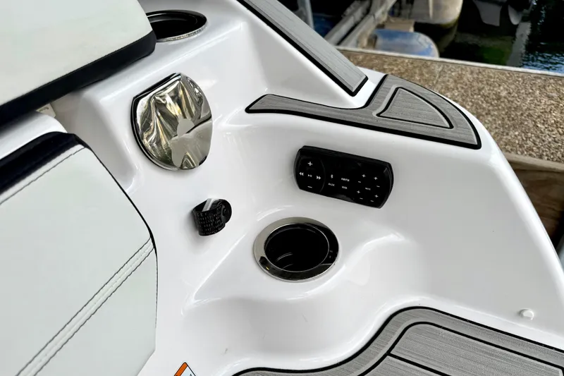 Slide: The Image of 2025 Yamaha Boats 252SE interior detail with control panel and cup holder. - 27