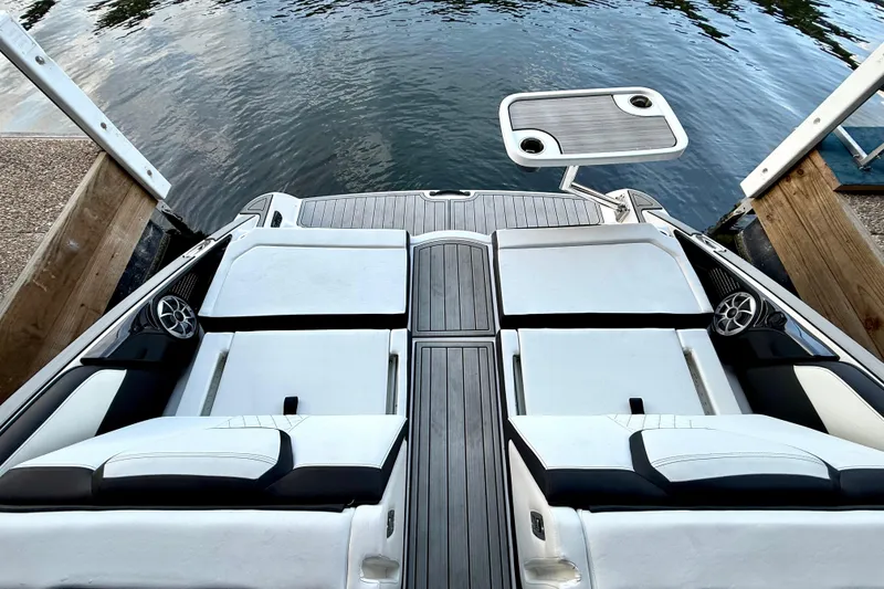 Slide: The Image of 2025 Yamaha Boats 252SE with sleek seating and table, docked by the water. - 29