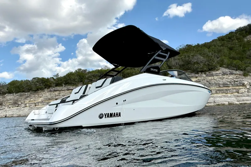 Slide: The Image of 2025 Yamaha Boats 252SE on water, sleek design, scenic backdrop, partly cloudy sky. - 3