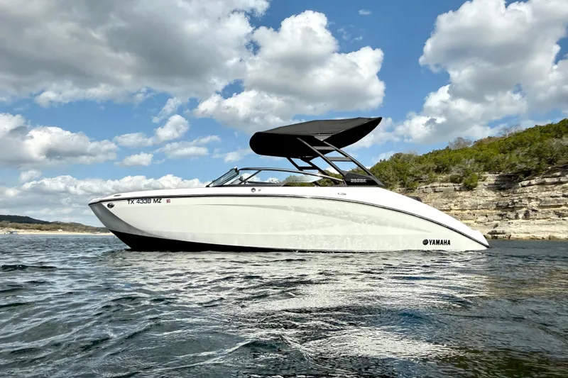 Slide: The Image of 2025 Yamaha Boats 252SE on water, sleek design, under a partly cloudy sky. - 6