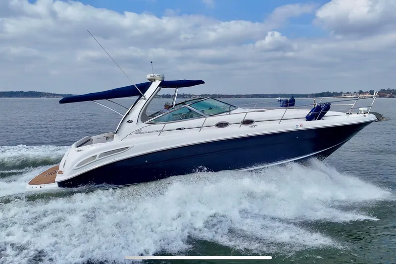 The Image of 2005 Sea Ray 360 Sundancer cruising on open water under a cloudy sky. - 0