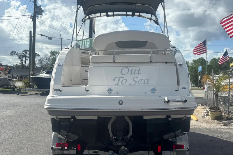 Slide: The Image of 2007 Chaparral Signature 250 boat with "Out To Sea" text, parked outdoors. - 2