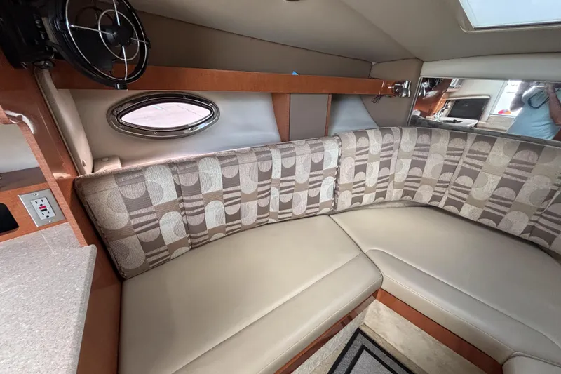 Slide: The Image of 2007 Chaparral Signature 250 cabin interior with patterned seating and porthole window. - 26