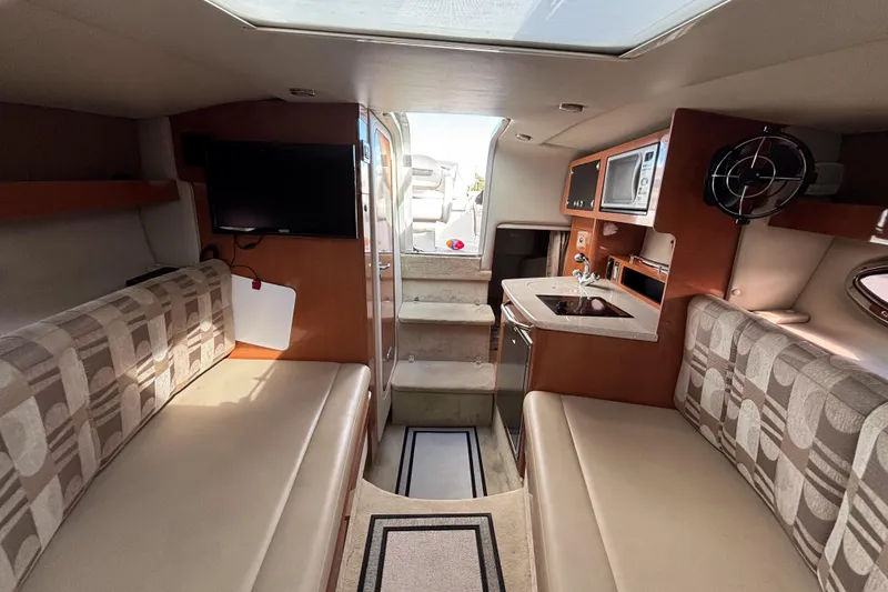 Slide: The Image of Interior of 2007 Chaparral Signature 250 boat with seating, kitchenette, and TV. - 29