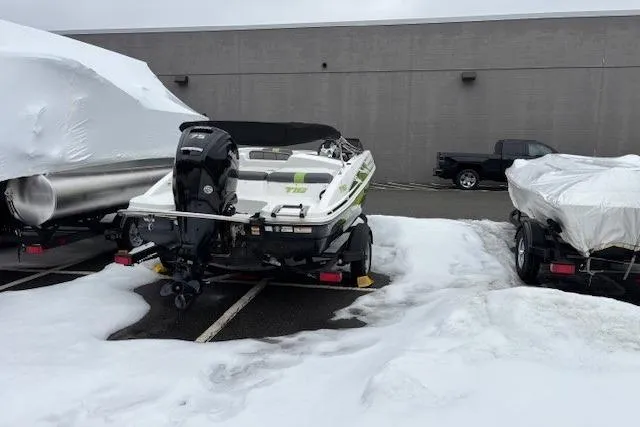 Slide: The Image of 2021 Tahoe T16 boat with outboard motor on a trailer, parked outdoors. - 4