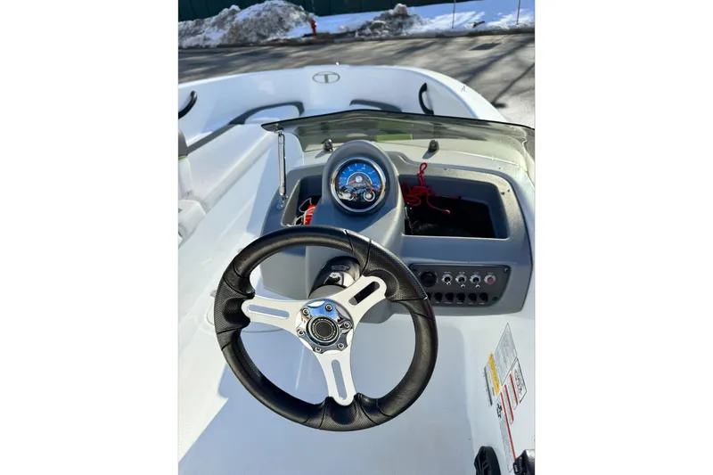 Slide: The Image of 2021 Tahoe T16 boat dashboard with steering wheel and control panel. - 5