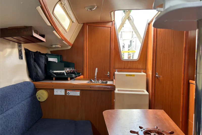 Slide: The Image of Interior of 2008 Hunter 27 sailboat with wooden cabinetry and steps. - 12