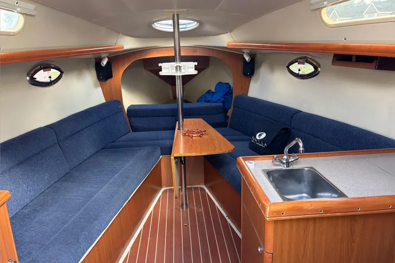 Slide: The Image of Interior of 2008 Hunter 27 sailboat with wooden cabinetry and compact kitchen area. - 13