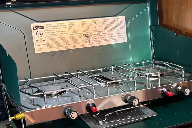 Slide: The Image of Interior cabin of a 2008 Hunter 27 sailboat with wood paneling and a patterned bedspread. - 15