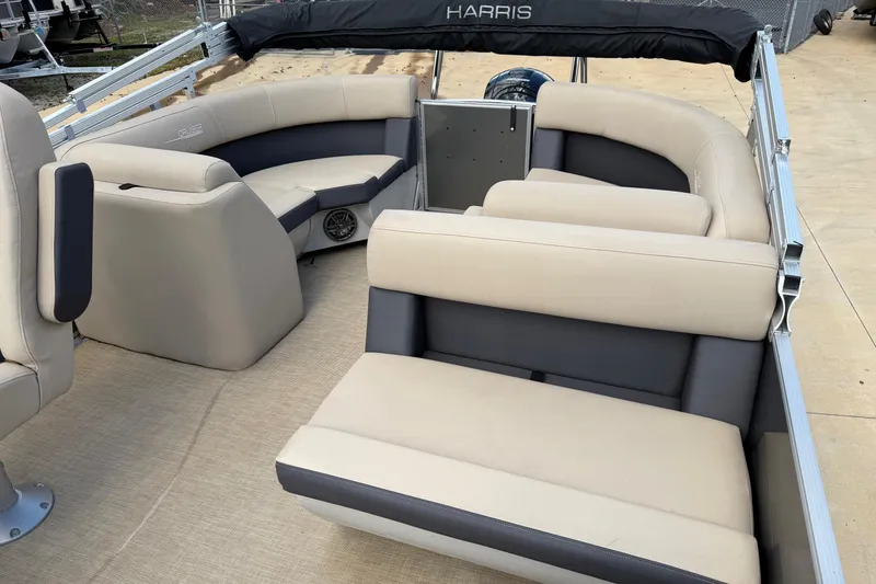 Slide: The Image of 2024 Harris Cruiser 230 pontoon boat with beige and gray seating, docked on a sunny day. - 4
