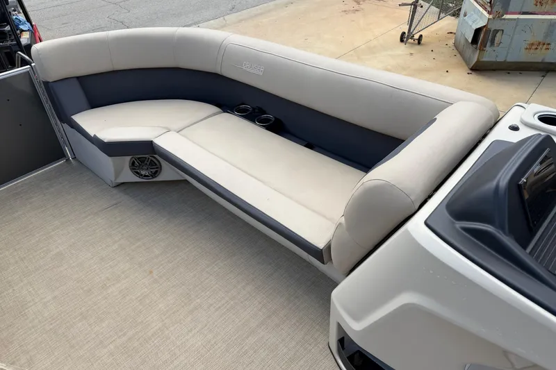 Slide: The Image of 2024 Harris Cruiser 230 boat interior with beige seating and cup holders. - 6