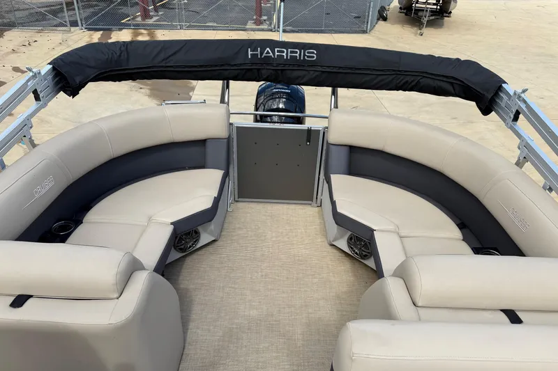 Slide: The Image of 2024 Harris Cruiser 230 pontoon boat with beige seating and black canopy. - 8