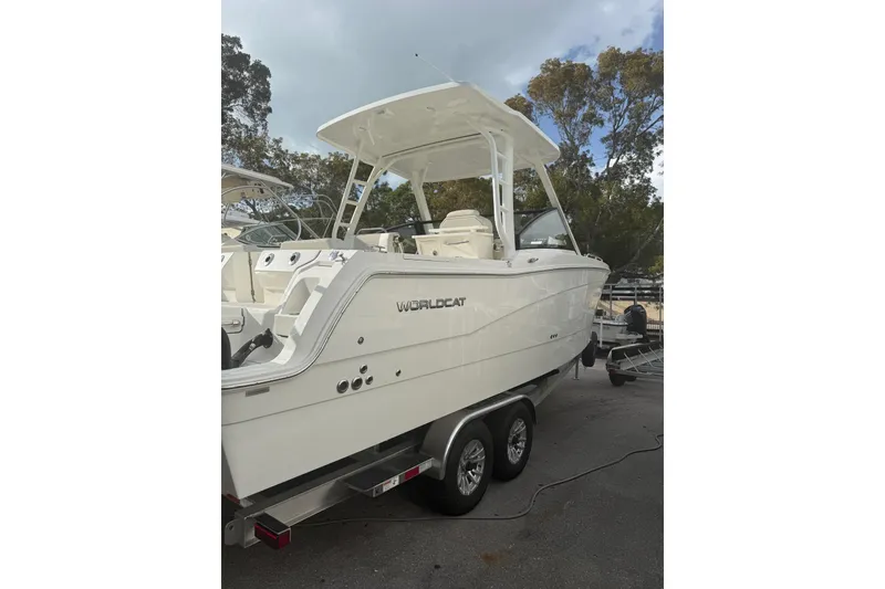 The Image of 2026 World Cat 265 DC-X boat on trailer, white exterior, parked outdoors. - 0