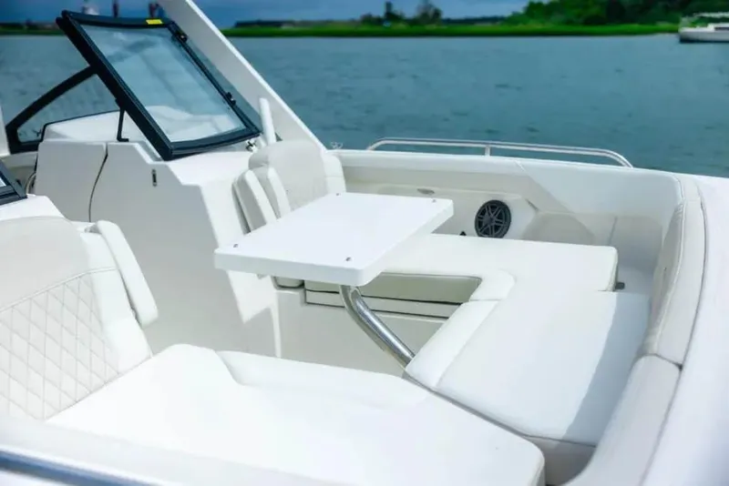 Slide: The Image of Manufacturer Provided Image: 2026 World Cat 265 DC-X boat interior with white seating and table on a calm water backdrop. - 15