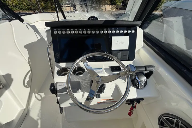 Slide: The Image of 2026 World Cat 265 DC-X boat helm with steering wheel and control panel. - 3